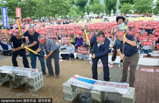 图为首尔市民举牌静坐抗议，强烈反对在韩部署萨德反导系统。