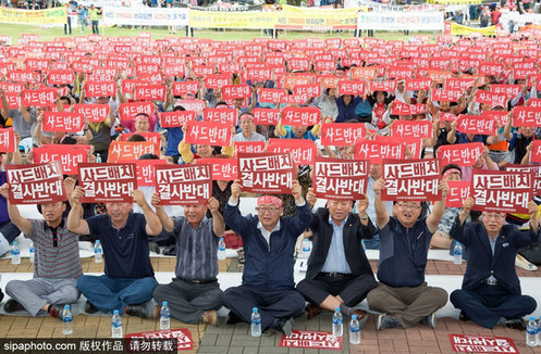 图为首尔市民举牌静坐抗议，强烈反对在韩部署萨德反导系统。